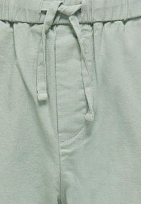 Hellgrüne Leinen-Shorts mit elastischem Bund und Kordelzug, seitlichen Taschen und strukturiertem Finish.