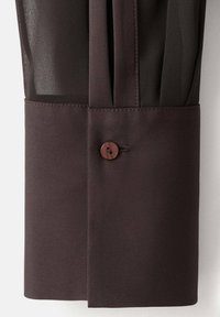 Dark brown fabric with a textured finish, featuring a smooth cuff and a wooden button detail. The design includes pleating for added style.
