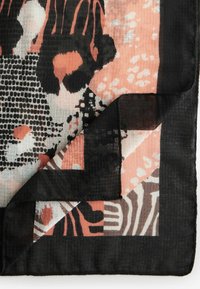 Monivärinen huivi, jossa on musta ja korallinvärinen abstrakti kuvio, teksturoitu kudonta ja pehmeä, kevyt kangas, jossa on fringed-reuna.