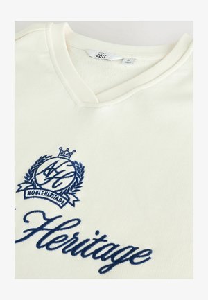 Biele tričko s krátkym rukávom a výstrihom do V vyrobené z rebrovanej látky, s námorníckymi modrými vyšívanými logom a textom vpredu.