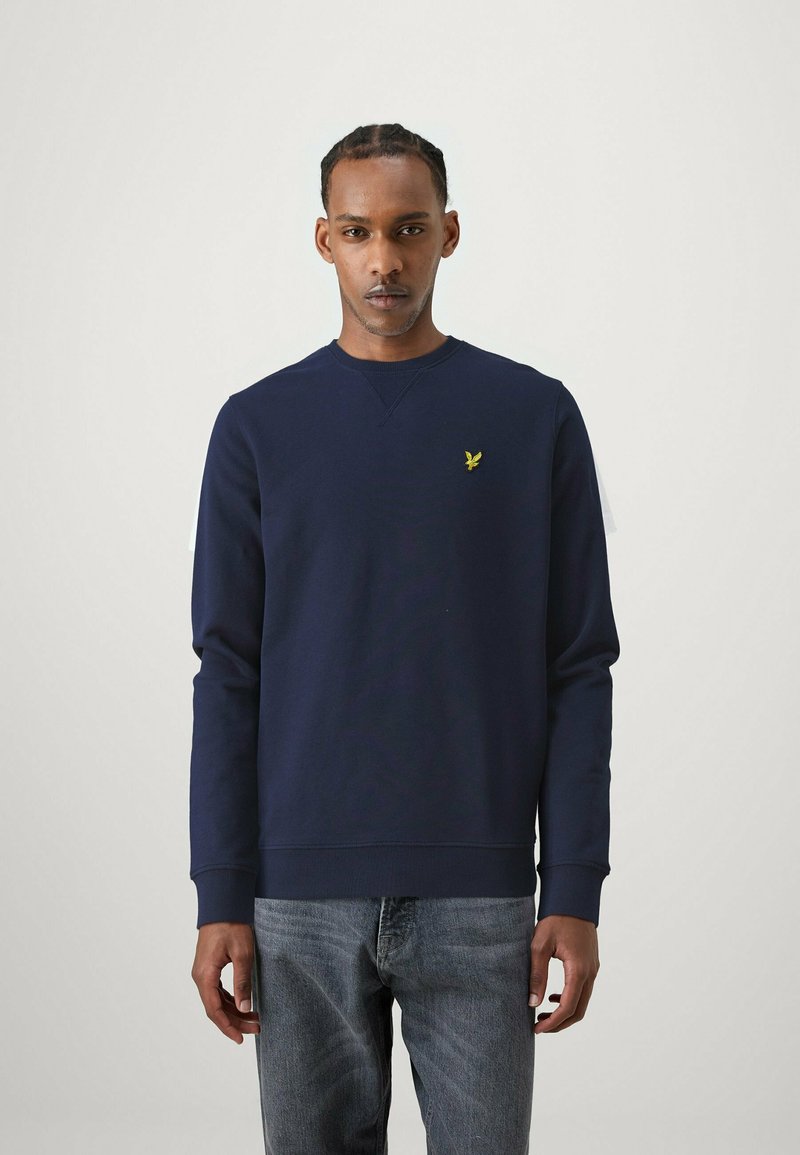Felpa blu navy in misto cotone, con scollatura rotonda e polsini a coste. Piccolo logo giallo sul lato sinistro del petto, design semplice e classico.