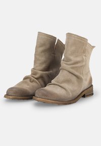 Botines beige de cuero perforado, con un diseño arrugado, puntera redondeada y un bajo tacón de madera apilada. Acabado envejecido en la puntera.