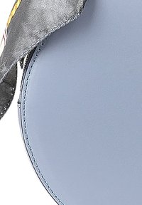 Ronde tas van soepel lichtblauw leer met een contrasterende, gestreepte stofaccent. Bevat stiksels langs de randen en een ritssluiting.