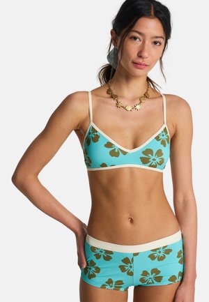 Set bikini azzurro chiaro con bralette triangolare e boyshorts, entrambi decorati con grandi stampe floreali marroni e bordo color crema.