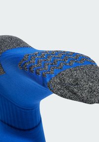 Blue sock with a textured gray toe and heel. Features a smooth upper section and a zigzag pattern on the toe area.