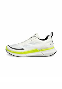 Scarpa sportiva bianca con tomaia traspirante, dettagli in neon giallo, rifiniture nere e suola testurizzata, dotata di una linguetta sul tallone.