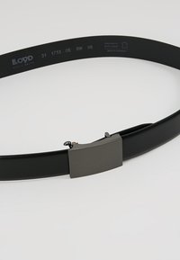 Ceinture en cuir noir avec une boucle en métal texturée. Présente une finition lisse, un design ajustable et un logo de marque subtilement gravé à l'intérieur.