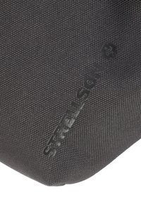 Czarna, teksturowana tkaninowa saszetka z wytłoczonym logo "Strellson", charakteryzująca się gładkim, zaokrąglonym kształtem i subtelnym, tkanym zdobieniem.