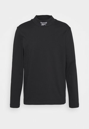 Czarna koszulka Reebok z długim rękawem i kołnierzykiem typu mock neck, z logo Reebok i symbolem wektora w białym kolorze na kołnierzu.