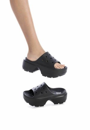 Zuecos negros con punta abierta, que cuentan con una suela gruesa y texturizada, agujeros de ventilación y un diseño superior suave. Ligero y de forma ergonómica.