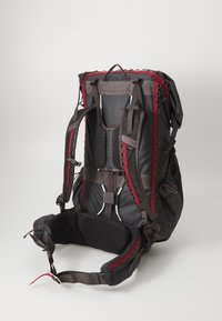 Black backpack with red accents, featuring padded shoulder straps, a mesh back, and adjustable hip belt. Detailed design for comfort and functionality.