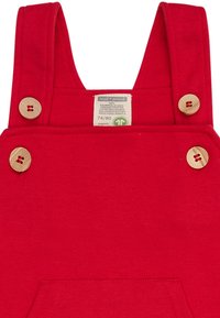 Rote Baumwoll-Overalls mit breiten Trägern, Holzknöpfen und einer Fronttasche. Das Etikett trägt die Aufschrift "loud + proud", Größe 74/80, aus biologischem Material.