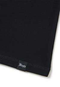 Camiseta de algodón negra con una textura suave, que presenta un dobladillo cosido y una pequeña etiqueta tejida que muestra "Utopia" en la esquina inferior izquierda.