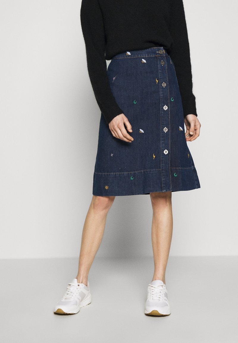 Denim skirt in dark blue, featuring a-line shape, embroidered designs including stars and suns, and front button closure.