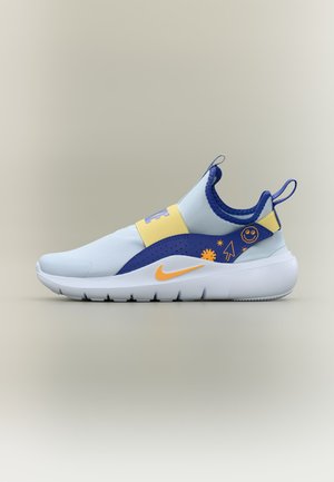 Pantof sport slip-on albastru deschis cu curea galbenă, accente albastre la călcâi cu grafice cu fețe zâmbitoare și săgeți, și swoosh Nike portocaliu pe talpă albă.