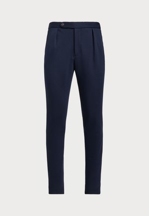 Pantalons ajustés bleu marine avec un devant plat, deux plis avant et une fermeture à un bouton, en tissu lisse et texturé.