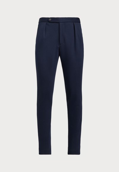 Marineblauwe op maat gemaakte broeken met een vlakke voorkant, twee plooien aan de voorzijde en een enkele knoopsluiting, gemaakt van een gladde, gestructureerde stof.