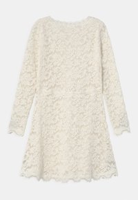 Ivory lace dress with long sleeves, floral patterns, and a scalloped hem. Lightweight with a textured finish and round neckline.