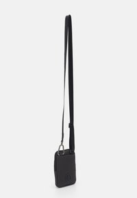 Sort crossbody taske lavet af tekstureret stof, kvadratisk form med et frontlogo, og en justerbar rem med en metalspænde for sikker lukning.