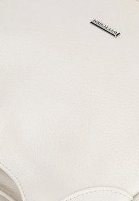 Borsa in pelle bianca con una texture liscia, caratterizzata da una placca logo argentata. Il design include bordi arrotondati e dettagli di cucitura minimi.