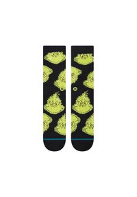 Calzini neri con volti del Grinch verdi ripetuti e occhi gialli; texture morbida con un accento blu attorno ai polsini.