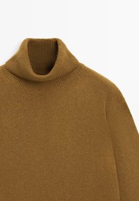 Maglione a collo alto lavorato a maglia marrone con colletto a coste, caratterizzato da una texture liscia e una vestibilità ampia, ideale per sovrapporre.