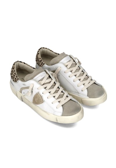Par de zapatillas blancas y beige con detalles en el talón de estampado de leopardo y cordones beige, ligeramente usadas sobre un fondo blanco.