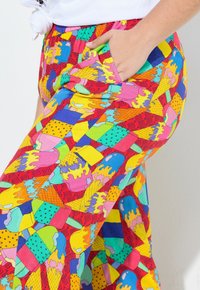 Pantaloni colorati e larghi con un motivo giocoso di gelati e geometrico. Realizzati in tessuto leggero, presentano una vita elasticizzata e una tasca laterale.