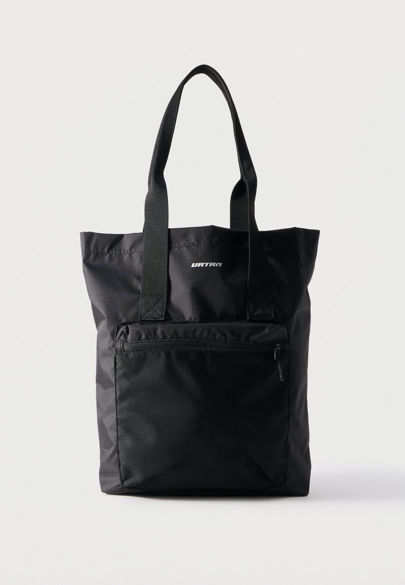 Μαύρη τσάντα ώμου με μακριές λαβές, εμπρόσθια τσέπη από δίχτυ με φερμουάρ και μικρό λευκό λογότυπο στο κέντρο κοντά στην κορυφή.