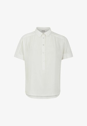 Īsām piedurknēm baltā blūze ar pogu aizdari priekšpusē, mīksta auduma un smalkām krokām plecos; noapaļots apakšmalas dizains ar brīvu piegriezumu.