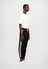 EA7 Emporio Armani PANTALONI - Treniņtērpa apakšdaļas - black