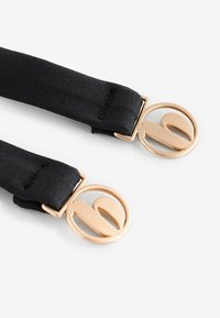 Bretele elastice negre cu cleme rotunde din metal auriu, cu un design stilizat al literelor, având o textură netedă și un design minimalist.