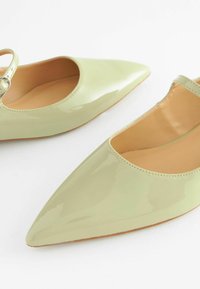 Mintgrüne Ballerinas mit spitz zulaufender Zehenpartie aus Lackleder, ausgestattet mit einem verstellbaren Knöchelriemen und einer glatten, glänzenden Oberfläche.