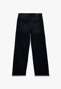 Czarne dżinsy w prostym kroju, z dwoma tylnymi kieszeniami i naszywką w pasie. Lekko zaciemniony materiał.