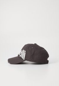 Svart baseballcaps i bomull med buet skygge og hvit tekstdesign foran. Har justerbar stropp bak.