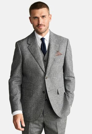 Gray wool suit with a structured jacket, matching vest, and tailored trousers. Features notch lapels, a white dress shirt, and a textured tie.