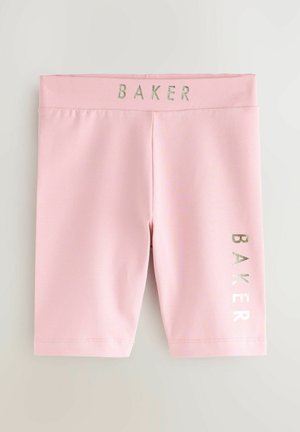 Shorts rose clair arrivant au genou avec un texte argenté brillant "BAKER" sur la ceinture et la jambe droite, posés à plat sur un fond blanc.