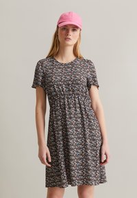 Korte mouw jurk in een donker bloemenpatroon met roze en blauwe bloemen. Vergezeld van een lichtroze pet. Casual en lichtgewicht ontwerp.