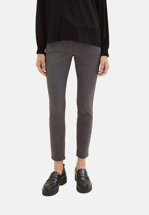 Pantalons ajustés gris en tissu mélangé coton, avec une texture lisse et une taille mi-haute. Associés à des mocassins noirs.