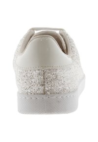 Vita sneakers med en glittrig ovandel, en slät plast hälkappa och en strukturerad gummisula. Har snörning och rundad form.