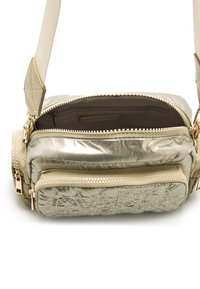Metallisch goldene Schultertasche mit texturierter Oberfläche, zwei Reißverschlussfächer und einem cremefarbenen Trageriemen. Besitzt ein gewebtes Logodetail auf der Vorderseite.