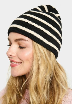 Black and cream striped knitted beanie with a ribbed texture. Features a close-fitting design, suitable for various head shapes.