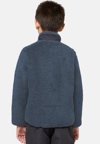Veste en polaire bleu foncé avec un extérieur texturé et doux. Elle présente un col haut et une coupe décontractée, vue de dos.