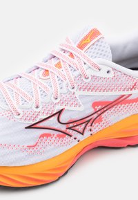 Scarpa da corsa con parte superiore in rete bianca, accenti rosa, logo nero e suola multicolore con elementi arancioni e rosa.