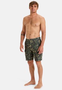 Kraťasy na plávanie s maskáčovým vzorom v odtieňoch zelenej, vo voľnom strihu, so bočnými vreckami a plochou prednou časťou. Vyrobené z ľahkej látky.