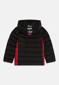 Czarna kurtka puchowa z czerwonymi panelami bocznymi i kapturem, z białym napisem "JORDAN" oraz czerwonym logo Jumpman na kapturze, widoczna od tyłu.