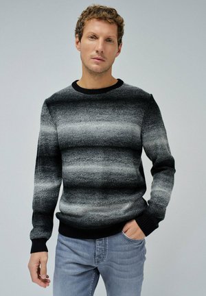 Suéter de punto a rayas negro y gris con manga larga, cuello redondo acanalado y tejido texturizado. Llevado con jeans grises.
