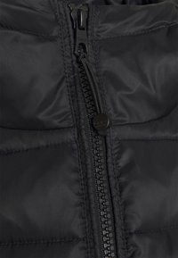 Černá prošívaná bunda s hladkým povrchem, centrálním zipem, krytem zipu a horizontálním prošíváním.