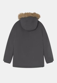 Parka gris foncé avec une bordure en fausse fourrure sur la capuche, manches longues et coupe droite. La surface semble lisse et imperméable.