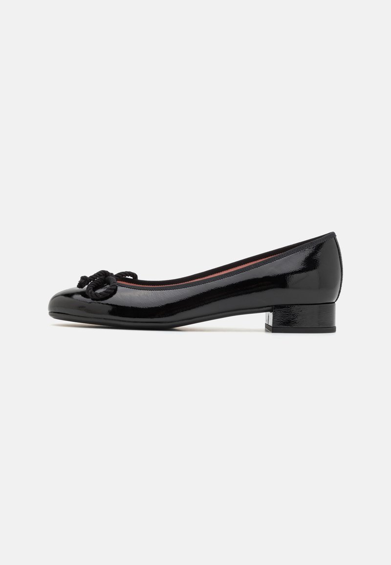 Ballerine en cuir verni noir avec un bout arrondi, un petit talon bloc et un accent décoratif en nœud à l'avant. Texture lisse et brillante.